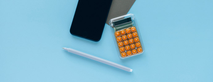 Photographie d'une calculatrice, d'un iphone et d'un crayon