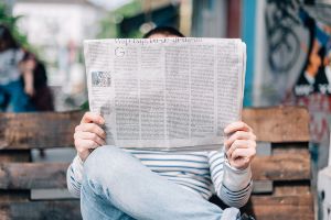 Photographie d'un homme lisant le journal